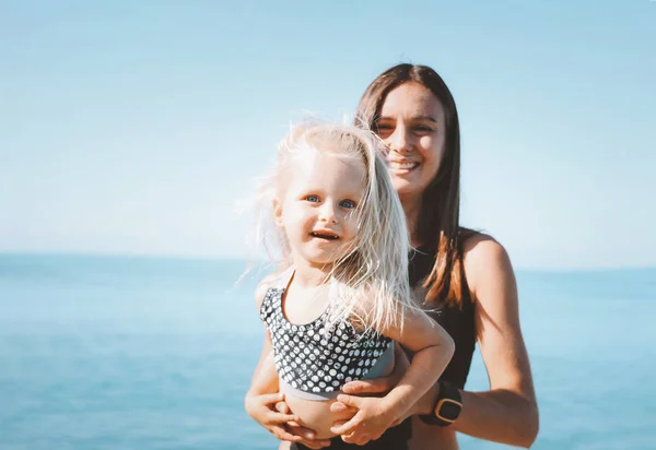 젊은 맞는 여자 엄마와 함께 바다 해변에서 운동 하는 작은 귀여운 여자, 건강 한 라이프 스타일 — 스톡 사진