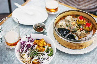 Pan-Asya gıda - bambu kase ve salata farklı dim sums. Bira ile iki öğle yemeği