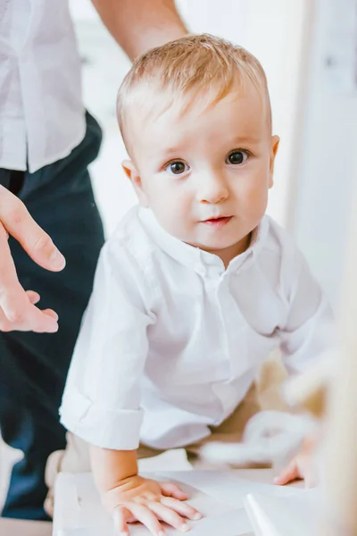 Симпатичный мальчик в белой рубашке с руками его fother в ярком интерьере, крупным планом портрет — стоковое фото