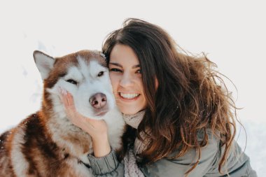 Soğuk sezonda ormanda açık havada metresi esmer kız ile Kırmızı köpek husky