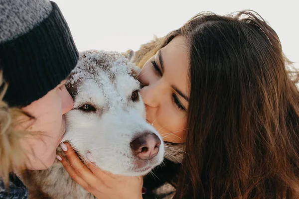 Το ευτυχισμένο ζευγάρι που φιλιέται με σκύλους στο δασικό πάρκο, την κρύα σεζόν. Ταξίδια περιπέτεια ιστορία αγάπης — Φωτογραφία Αρχείου
