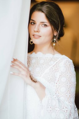 Pencere yakınında beyaz dantel elbise güzel gülümseyen gelin esmer genç kadın, portrai yakın