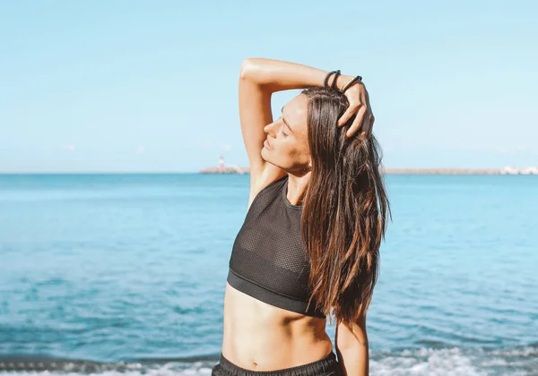 Joven delgado atlético pelo largo sensual mujer en ropa deportiva en la playa del mar, estilo de vida saludable — Foto de Stock