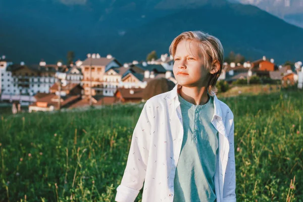 Blonde smiling boy on background of wonderful view of the mountain resort, family travel adventure lifestyle — Stock Photo, Image