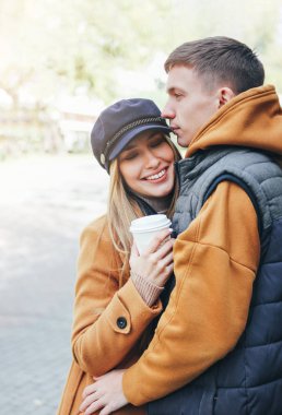 Soğuk sezonda şehir caddesinde birlikte yürüyen rahat bir tarzda giyinmiş aşık gençler arkadaşlar mutlu genç çift