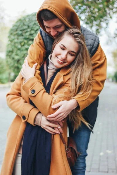 Feliz joven pareja enamorada adolescentes amigos vestidos con estilo casual en la calle de la ciudad de otoño — Foto de Stock