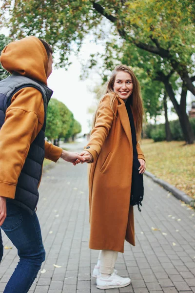 Felice giovane coppia innamorata adolescenti amici vestiti in stile casual seduti insieme sulla strada della città di autunno — Foto Stock