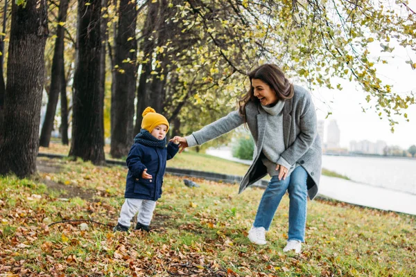 평상복 차림의 귀여운 사내 아기가 가을 자연 공원에서 엄마와 함께 세계를 탐험 한다 — 스톡 사진