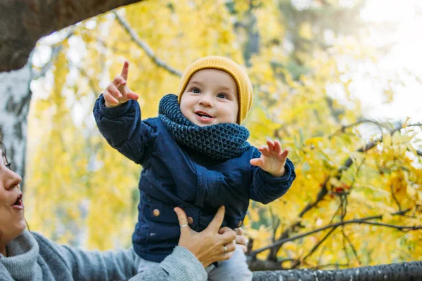 Милый мальчик в повседневной одежде исследует мир с матерью осенью в природном парке — стоковое фото