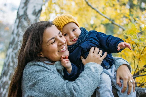 Porträtt av lycklig mor med pojke i höstparken — Stockfoto