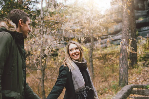 Glückliches junges verliebtes Paar Freunde in lässiger Kleidung, die in der kalten Jahreszeit gemeinsam auf dem Naturparkwald spazieren gehen, Familienausflug — Stockfoto