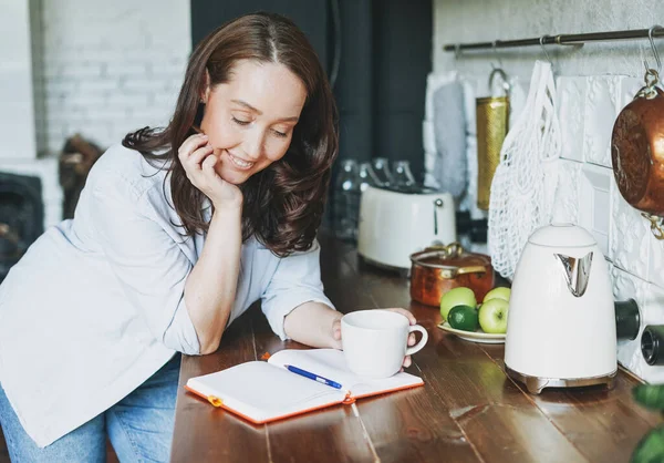 Adulto Sorridente Donna Bruna Casuale Facendo Note Nel Libro Quotidiano — Foto Stock