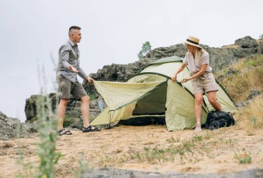 Sıradan kıyafetlerle gezen mutlu genç çiftler dağlara çadır kurdular. Yerel turizm, hafta sonu gezisi konsepti