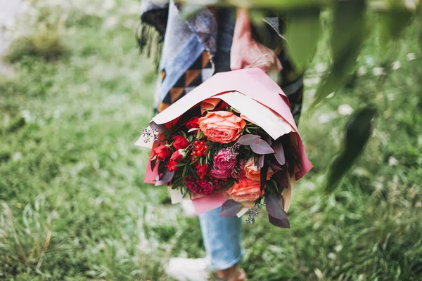 Młoda Kobieta Ponczo Dżinsach Posiada Piękny Bukiet Różnych Kwiatów Odcieniach — Zdjęcie stockowe