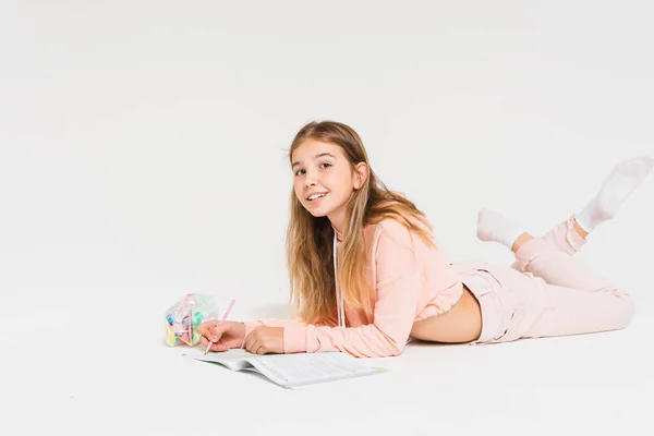 可爱的笑着的少女 长发粉红帽衫 在白色背景下独立做作业 — 图库照片