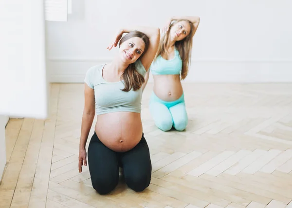 Groep Van Zwangere Vrouwen Sport Uniformen Doen Gymnastiek Heldere Studio — Stockfoto