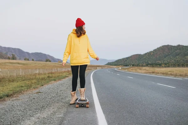 Jovem Mulher Capuz Amarelo Chapéu Vermelho Skate Estrada Contra Bela — Fotografia de Stock