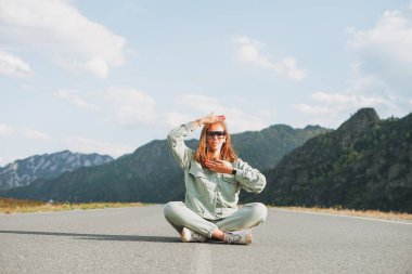 Yoldaki günlük kıyafetlerle, dağlara seyahat ederek, Altai 'de güzel, gülümseyen genç kadın gezgin.