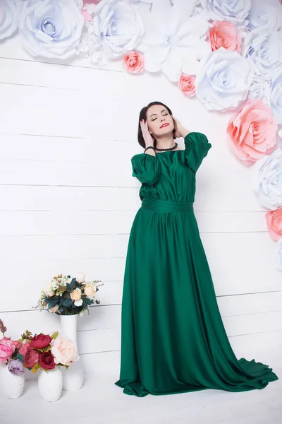 Açık Renkli Çiçekler Ile Poz Yeşil Elbiseli Güzel Esmer Kadın — Stok fotoğraf
