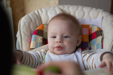 İlk bebek kaşık gelen besleme. Anne beslemeleri bebek homojenize kıyılmış gıda bir kaşıkla. Çocuk Bakımı