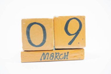 9 Mart. Gün 9 ay, beyaz arka plan üzerinde izole el yapımı ahşap takvim. Bahar ay, gün yıl kavramın.
