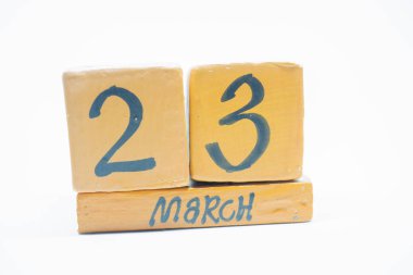 23 Mart. gün 23 ay, beyaz arka plan üzerinde izole el yapımı ahşap takvim. Bahar ay, gün yıl kavramın.