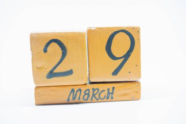 29 Mart. Ayın, beyaz arka plan üzerinde izole el yapımı ahşap takvim gün 29. Bahar ay, gün yıl kavramın.