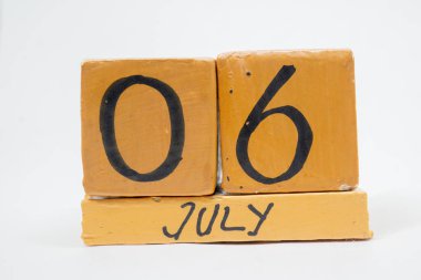 6 Temmuz. Gün 6 ay, beyaz arka plan üzerinde izole el yapımı ahşap takvim. yaz ay, gün yıl kavramın.
