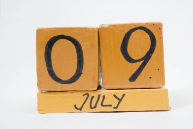 9 Temmuz'da. Gün 9 ay, beyaz arka plan üzerinde izole el yapımı ahşap takvim. yaz ay, gün yıl kavramın.