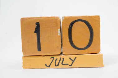 Temmuz 10. Gün 10 ay, beyaz arka plan üzerinde izole el yapımı ahşap takvim. yaz ay, gün yıl kavramın.