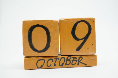 9 Ekim. Gün 9 ay, beyaz arka plan üzerinde izole el yapımı ahşap takvim. Sonbahar ay, gün yıl kavramın.