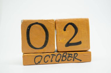 2 Ekim. Gün 2 ay, beyaz arka plan üzerinde izole el yapımı ahşap takvim. Sonbahar ay, gün yıl kavramın.
