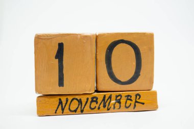 10 Kasım. Gün 10 ay, beyaz arka plan üzerinde izole el yapımı ahşap takvim. Sonbahar ay, gün yıl kavramın.