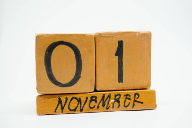 Kasım 1. gün 1 ay, beyaz arka plan üzerinde izole el yapımı ahşap takvim. Sonbahar ay, gün yıl kavramın.