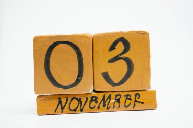Kasım 3. gün 3 ay, beyaz arka plan üzerinde izole el yapımı ahşap takvim. Sonbahar ay, gün yıl kavramın.
