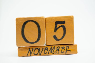 5 Kasım. Gün 5 ay, beyaz arka plan üzerinde izole el yapımı ahşap takvim. Sonbahar ay, gün yıl kavramın.