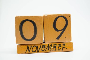 9 Kasım. Gün 9 ay, beyaz arka plan üzerinde izole el yapımı ahşap takvim. Sonbahar ay, gün yıl kavramın.