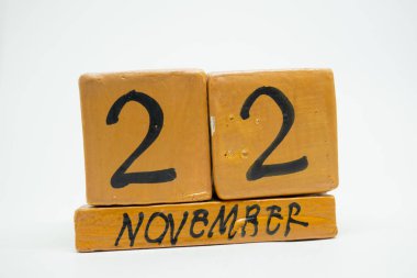22 Kasım. Ayın, beyaz arka plan üzerinde izole el yapımı ahşap takvim gün 22. Sonbahar ay, gün yıl kavramın.