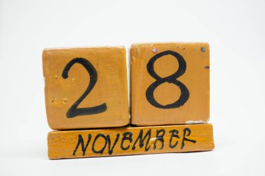 28 Kasım. Ayın, beyaz arka plan üzerinde izole el yapımı ahşap takvim günü 28. Sonbahar ay, gün yıl kavramın,.