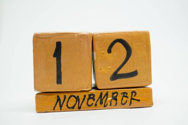 12 Kasım. Gün 12 ay, beyaz arka plan üzerinde izole el yapımı ahşap takvim. Sonbahar ay, gün yıl kavramın.