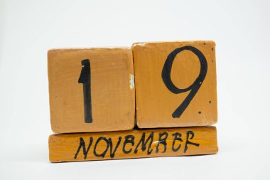 19 Kasım. Ayın, beyaz arka plan üzerinde izole el yapımı ahşap takvim gün 19. Sonbahar ay, gün yıl kavramın.
