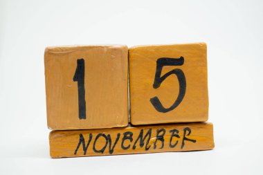 15 Kasım. Gün 15 ay, beyaz arka plan üzerinde izole el yapımı ahşap takvim. Sonbahar ay, gün yıl kavramın.