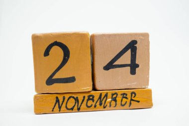 24 Kasım. Gün 24 ay, beyaz arka plan üzerinde izole el yapımı ahşap takvim. Sonbahar ay, gün yıl kavramın.