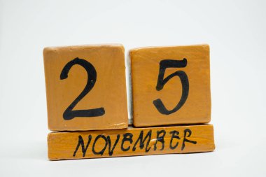 25 Kasım. Ayın, beyaz arka plan üzerinde izole el yapımı ahşap takvim gün 25. Sonbahar ay, gün yıl kavramın.