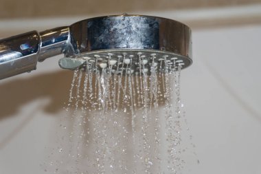 Banyodaki duş başlığından gelen su jeti..