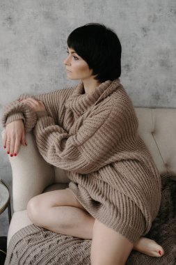 Güzel esmer kadın yatakta poz sıcak örme kazak