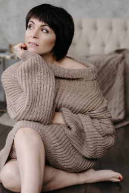 Güzel esmer kadın yatakta poz sıcak örme kazak