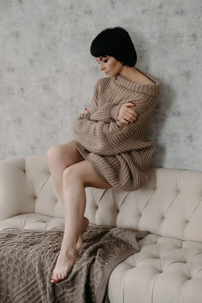 华丽的年轻黑发女人在温暖的针织毛衣摆在床上 — 图库照片