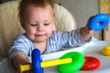 mutlu toddler bebek çocuk çocuk koltuğunda oturmak piramit renkli halkalar sıralama
