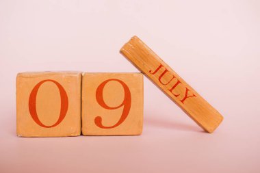 9 Temmuz. Gün 9 ay, modern renk arka planda el yapımı ahşap takvim. Yaz ayı, yılın günü konsepti